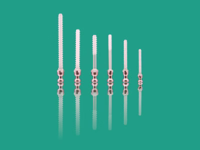 Six bioabsorbable screws with metal adapter against green background.